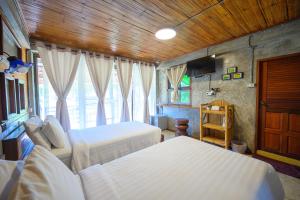 Ban Mae La Noiเฮินไต รีสอร์ท แม่ลาน้อย的一间卧室设有两张床和窗户。