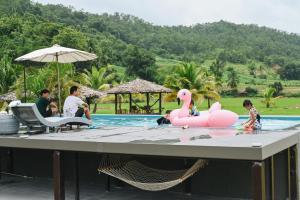 Ban Mae La Noiเฮินไต รีสอร์ท แม่ลาน้อย的游泳池内带粉红色火烈鸟的游泳池