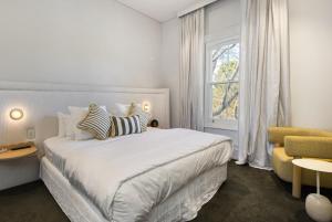 斯特灵The Stirling Hotel的白色的卧室设有床和窗户