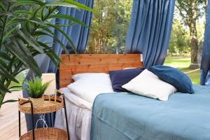 布罗斯Borås Camping & Vandrahem的一间卧室配有两张带蓝色窗帘和植物的床