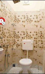 加尔各答Super OYO The Orchid Residency的浴室设有卫生间,墙上挂着金星。