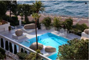蒙特卡罗Elegant Monaco Port de Fontvieille apartment with Garden View and Pool Access的游泳池位于海边的阳台上