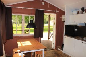 布罗斯Borås Camping & Vandrahem的厨房以及带桌子和窗户的用餐室。