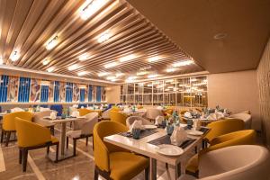 博帕尔Golden Tulip Bhopal的用餐室配有桌子和黄色椅子