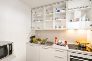 阿洛格诺Villa Delle Rose - Happy Rentals的厨房配有白色橱柜、水槽和微波炉