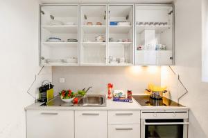 阿洛格诺Villa Delle Rose - Happy Rentals的厨房配有白色橱柜和水槽