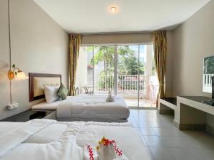 卡塔海滩Tri's Miracle Kata Beach Side的酒店客房设有两张床和一个阳台。