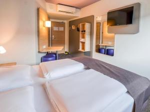 斯图加特斯图加特-瓦和因根住宿加早餐酒店的酒店客房设有两张床和一台平面电视。