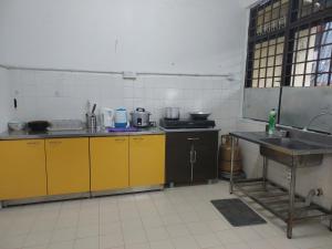 阿罗士打SDA Homestay Pool @StadiumDarulAman Untuk Muslim Sahaja的厨房配有黄色橱柜和水槽