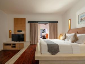塞米亚克The Seminyak Suite - Private Villa的一间卧室配有一张大床和一台平面电视
