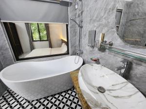 清化KL Retreat Hotel的带浴缸、水槽和镜子的浴室