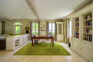 圣洛贝斯LA DEMEURE - Incroyable maison en bord de Dordogne的一个带书桌和绿色地毯的家庭办公室