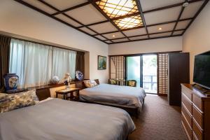 福冈梅光园别墅的酒店客房设有两张床和一台平面电视。