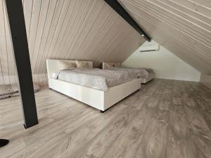 塔尔图Tartu Pajuoja saunamaja的一间卧室配有一张床,铺有木地板