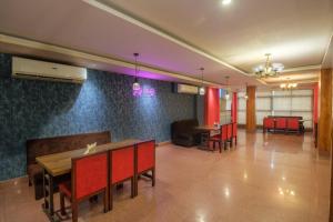 古瓦哈提Parnil Palace的一间用餐室,配有红色的椅子和桌子