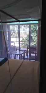 韦利格默Jagabay Resort & Surfing School的客房设有一张床和一个带桌椅的门廊。
