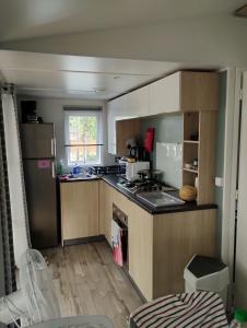 滨海皮里亚克MOBIL HOME的厨房配有木制橱柜和台面