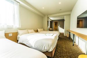浦安CVS海湾酒店的酒店客房设有三张床和电视。