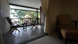 大松巴哇塞马沃过渡酒店的阳台配有两把椅子和一张桌子,还有一个窗户。