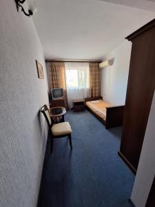 敖德萨Барселона的一间卧室,卧室内配有一张床和一把椅子