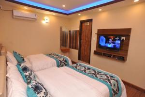 加德满都Hotel Arati Pvt. Ltd.的客房设有两张床和一台墙上的电视。