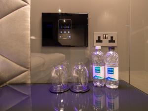 霍利Bloc Hotel London Gatwick Airport的玻璃桌旁的四瓶水