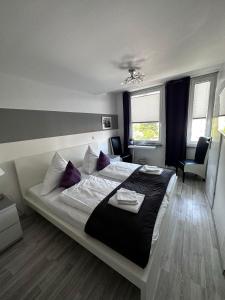 石勒苏益格德斯特施尔酒店的一间卧室配有一张带紫色枕头的大床