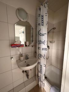 石勒苏益格德斯特施尔酒店的一间带水槽和淋浴帘的浴室