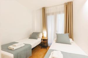 赫罗纳Bravissimo Plaça Catalunya, 2-bedroom apartment with terrace的带窗户的客房内设有两张单人床。