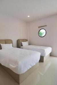 佛丕Chanmuang Resort ชานเมืองรีสอร์ท的白色客房的两张床,设有窗户