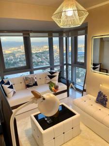 马尼拉Classy 2BR Suite at Eastwood City with Pool and City Skyline View的客厅配有沙发和桌子