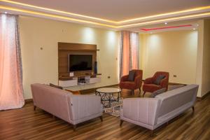 卢萨卡Ista Villa的客厅配有两张沙发和一台电视机