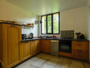 梅斯尼圣佩尔Maison chaleureuse avec son bain enchanté !的厨房配有木制橱柜和炉灶烤箱。