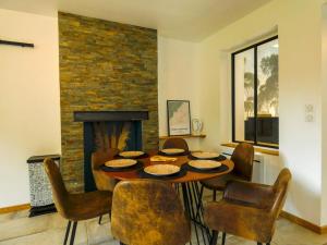 梅斯尼圣佩尔Maison chaleureuse avec son bain enchanté !的一间带桌椅和壁炉的用餐室