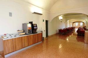 雷焦艾米利亚德拉吉亚拉学生宿舍旅馆的一间设有桌椅的大房间,提供自助餐