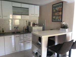 萨利Holiday home Dumboka的厨房配有白色橱柜、水槽和柜台。