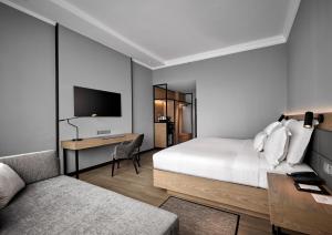 吉隆坡AC Hotel by Marriott Kuala Lumpur的一间卧室配有一张床、一张书桌和一台电视。