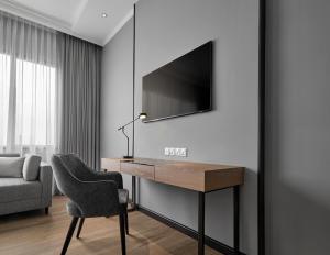 吉隆坡AC Hotel by Marriott Kuala Lumpur的客房设有一张桌子、一把椅子和一台电视。