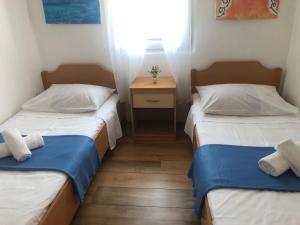 萨利Holiday home Dumboka的小型客房内的两张床,中间设有床头柜