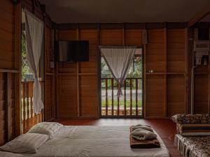 Pattani巴卡兰农场度假村的一间卧室设有一张大床和一个大窗户