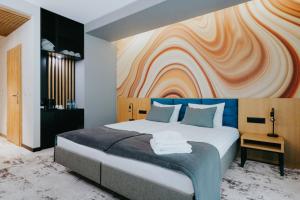 格武霍瓦济Aspen Prime Ski & Bike Resort - basen, sauna, jacuzzi, siłownia w cenie pobytu的一间卧室设有一张大床和色彩缤纷的墙壁