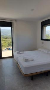 哈赖斯德拉韦拉Casa rural Atalanta de la Vera的白色的客房设有床和窗户。