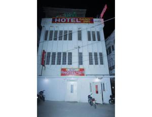 焦特布尔HOTEL SANDS INN, Jodhpur的两辆摩托车停在楼前的建筑物