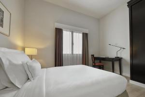 峇六拜AC Hotel by Marriott Penang的卧室配有一张白色大床和一张书桌