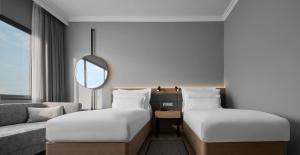 峇六拜AC Hotel by Marriott Penang的酒店客房,设有两张床和一张沙发