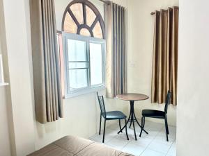 班敦孟PD Hostel的客房设有桌子、两把椅子和窗户。