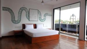 尼甘布City Beds Negombo的一间卧室设有一张床和一个大窗户