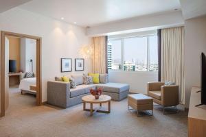 富查伊拉Doubletree By Hilton Fujairah City的客厅配有沙发和桌子