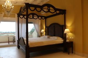 新马尔马拉斯克里坲斯酒店的一间卧室设有一张天蓬床和一个阳台