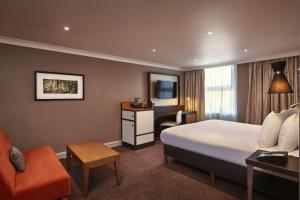 伦敦伦敦伊林希尔顿逸林酒店的配有一张床和一张书桌的酒店客房